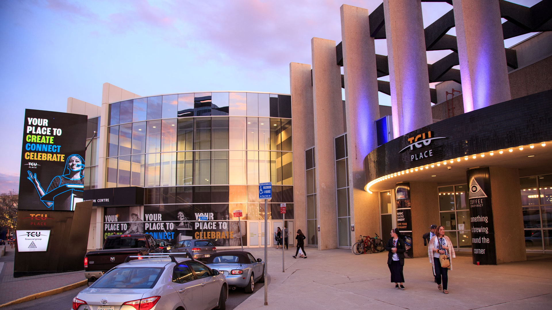 The front entrance and approach to TCU Place at dusk.